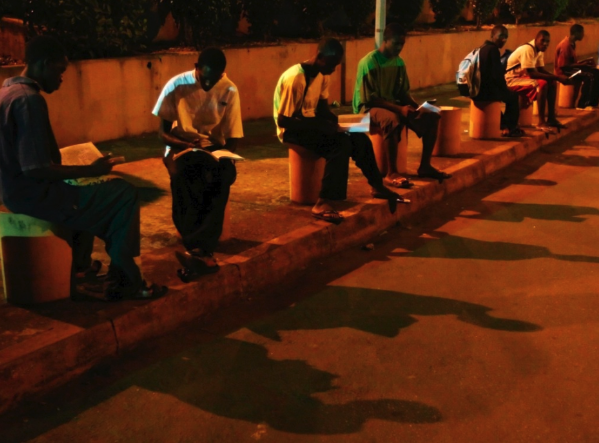 Image of teenagers studying under streetlights