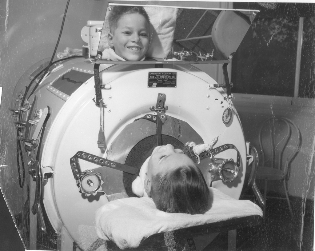 A boy with polio in the Emerson Respirator (Iron Lung) viewing the photographer (Joe Clark) in the machine's mirror. Herman Kiefer Hospital, Detroit, MI. National Museum of Health and Medicine.